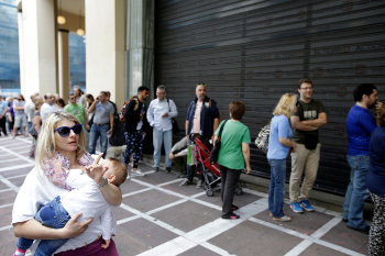 People stand in a queue outside a bank which operates on Saturday but eventually didn't open, in central Athens, June 27, 2015. Greece's fraught bailout talks with its creditors took a dramatic turn early Saturday, with the radical left government announcing a referendum in just over a week on the latest proposed deal — and urging voters to reject it. (AP Photo/Thanassis Stavrakis)